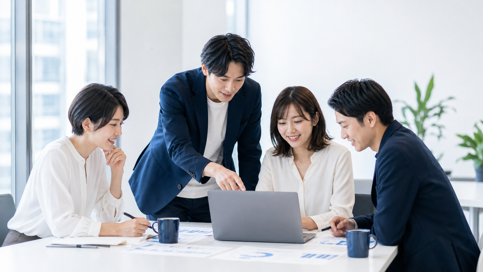 ノートPCを見ながら笑顔で学ぶチーム